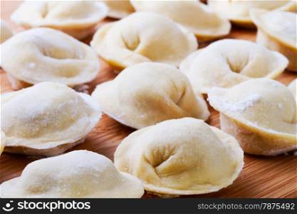 Background from russian crude pelmeni laid out on a chopping board