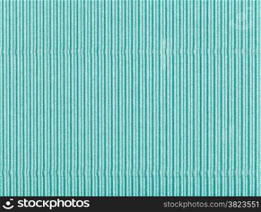 background from sheet of corrugated shiny green color paper close up