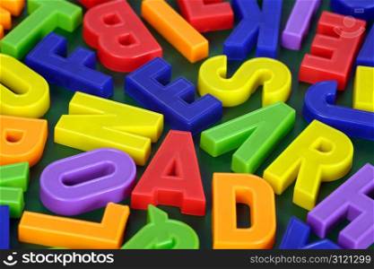Background image of magnetic alphabet letters. Focus is across the middle.