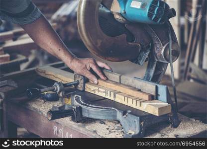 Background image of woodworking workshop: carpenters work table with different tools and wood cutting stand, vintage filter image