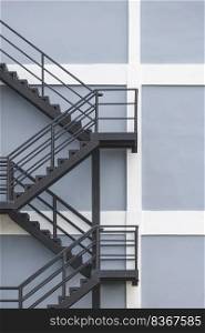 Background of black steel fire escape on gray and white building wall in under construction