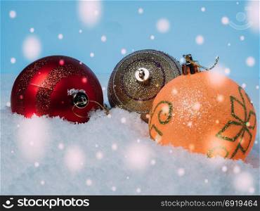 Background of Christmas balls on snow and falling snow on background.