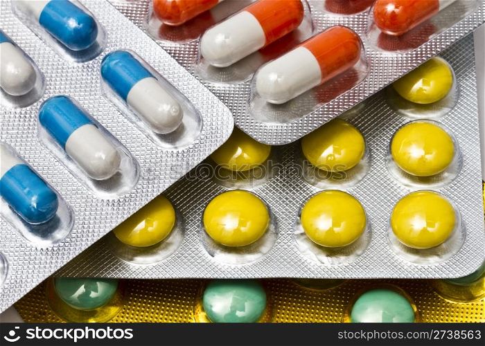 Background of colorful capsules and pills closeup