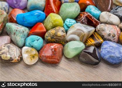 background of colorful, polished, semiprecious stone on grained wood