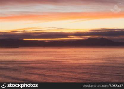 Background of colorful sky and ocean landscape. Dramatic sunset with twilight color sky and clouds.