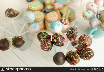 Background of decorated candies and cake pops on wooden boards