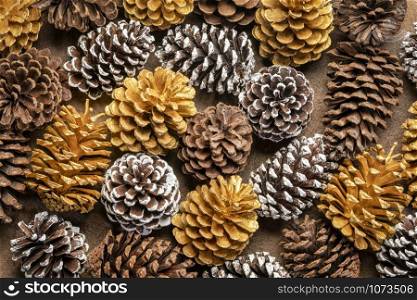 background of decorative pine cones - natural, gold and frosty white painted, winter holidays concept