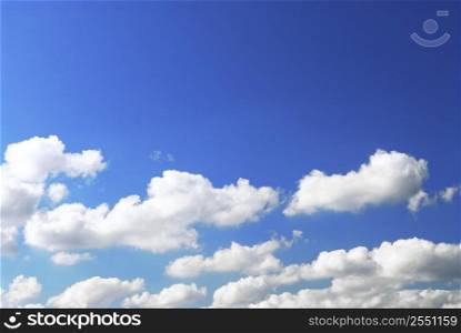 Background of deep blue sky with white fluffy clouds at the bottom