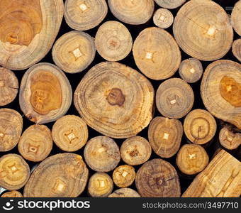 Background of dry teak logs stacked up on top of each other in a pile