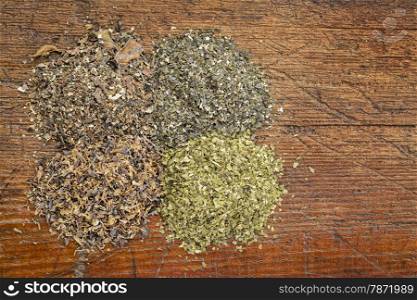 background of four seaweed dietary supplements (Irish moss, wakame, sea lettuce and bladderwrack) on a grunge wood