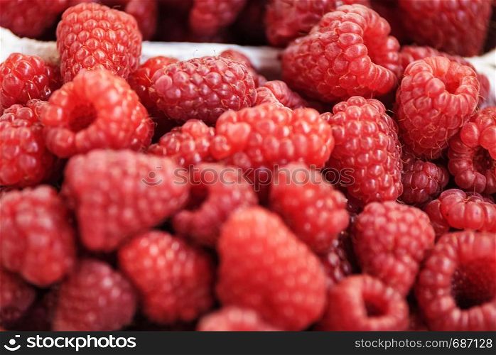 Background of fresh and juicy raspberries for sale at the market in close-up.