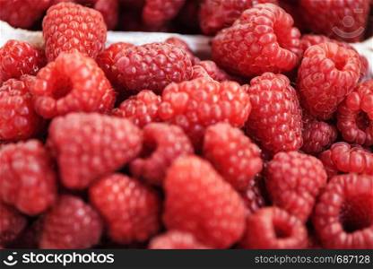 Background of fresh and juicy raspberries for sale at the market in close-up.