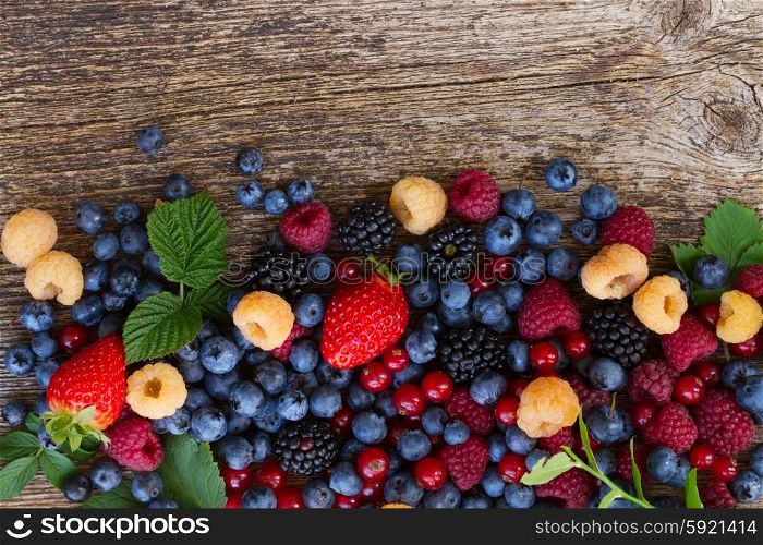background of fresh berries mix on wood, top view