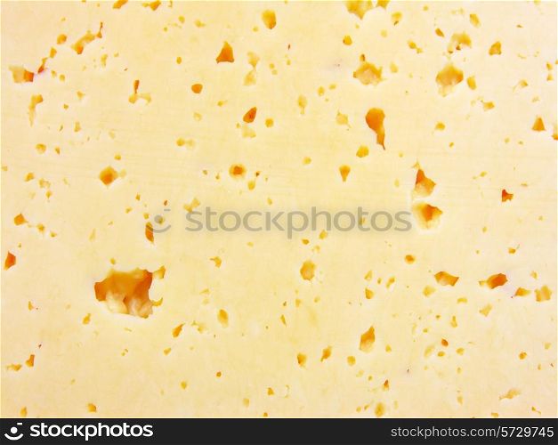 Background of fresh yellow Swiss cheese with holes