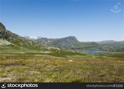 background of green hills and mountains in norway with blue sky background