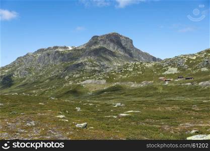background of green hills and mountains in norway with blue sky background