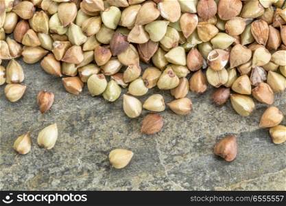 background of healthy, gluten free buckwheat grain on a slate rock