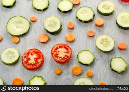Background of healthy products on a wooden table. Top view of vegetables - zucchini, tomatoes, cucumbers, carrots.