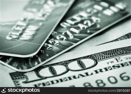 Background of hundred-dollar bills and credit cards stained in green tone
