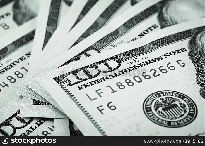 Background of hundred-dollar bills stained in green tone