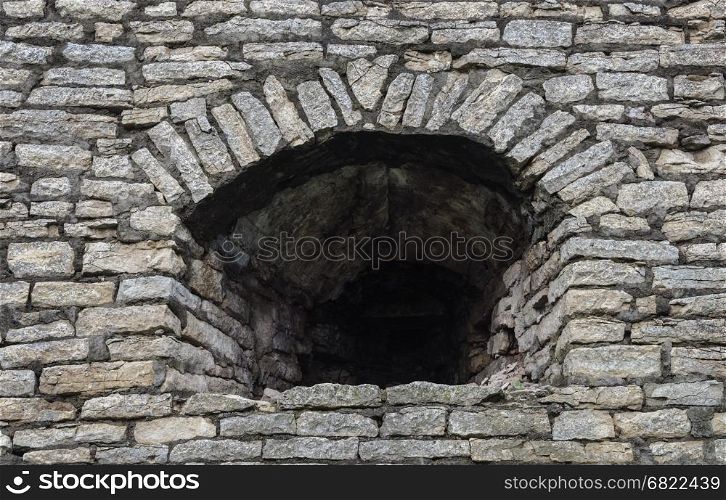 Background of old gray stone wall with embrasure in Krom (Kremlin) of Pskov