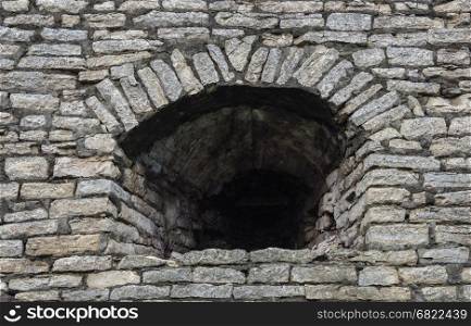 Background of old gray stone wall with embrasure in Krom (Kremlin) of Pskov