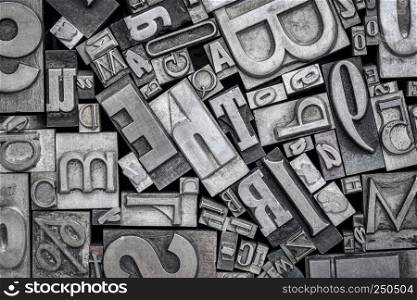 background of random vintage letterpress metal type printing blocks, black and white image