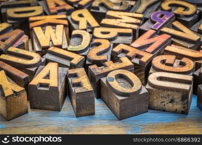 background of random vintage letterpress printing blocks on a grunge rustic wood