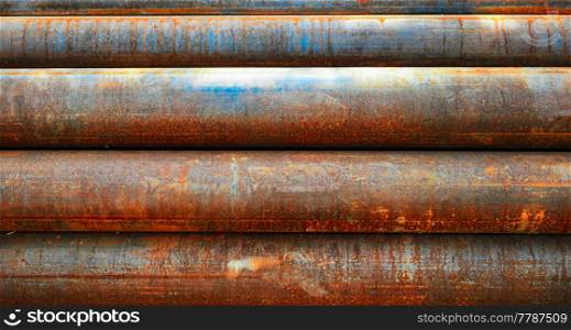 Background Of Rusty Pipes In Stack. Background Of Rusty Pipes