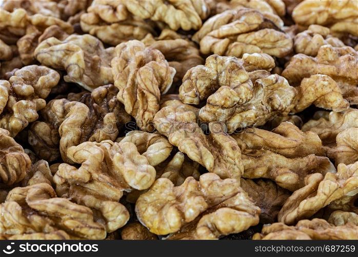 Background of shelled dried walnuts in close-up (high details)