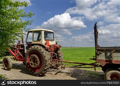 Background of sky, clouds, field and wheeled tractor, Ludogorie, Bulgaria