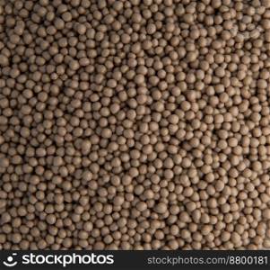 background of small plastic pellets brown colored. background of plastic pellets