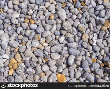 Background of smooth pebbles in different colors and sizes on the beach
