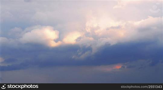 Background of stormy cloudy sky with sunlight shining through