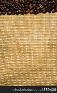 Background of the roasted coffee beans on a burlap piece