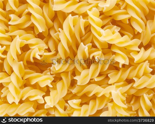 Background of twisted raw pasta scattered on the table