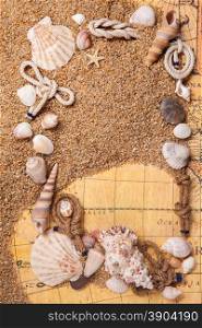 background of various shells on sand and old map. Top view. frame from various shells on sand and old map