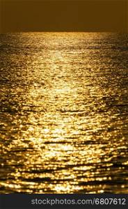 Background of water with golden sunrise reflections
