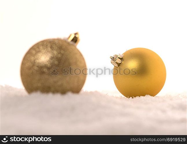 Background of yellow Christmas balls in the snow.