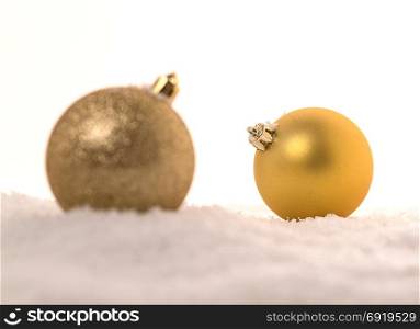 Background of yellow Christmas balls in the snow.