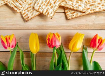 Background Religious Jewish holiday Pesach. Tulips and matzo on light wooden table. Happy Passover.. Background Religious Jewish holiday Pesach. Tulips and matzo on a light wooden table. Happy Passover.