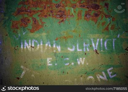 Background texture of a rusting old green painted metal sign.