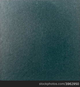 Background texture of a shiny metal sheet with a rough stippled textured surface reflecting light. Metal texture