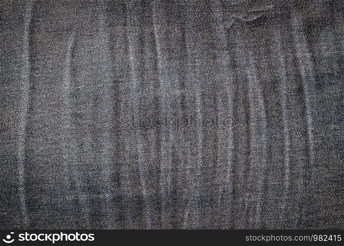 Background texture of old jeans with a pattern of wrinkles.