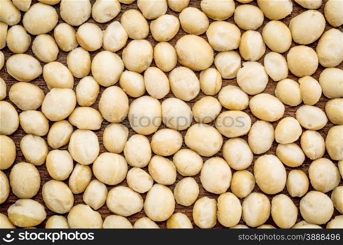 background texture of shelled macadamia nuts on rustic grunge wood - top view