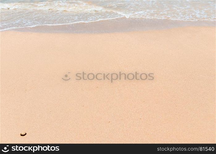 background wet sand on the beach and sea wave close-up