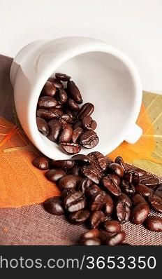 Background with coffee cup, autumn leaves and coffee beans