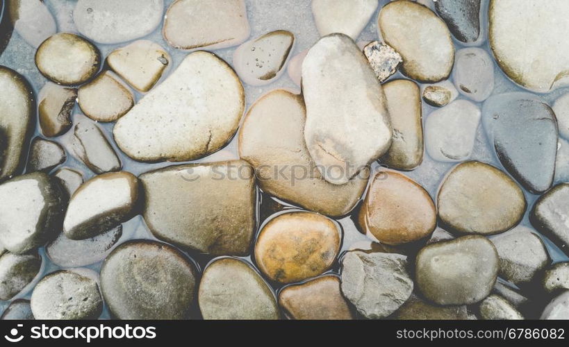 Background with colorful pebbles lying in water