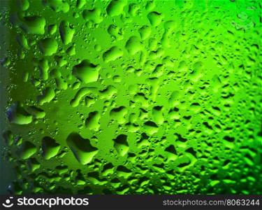 Background with drops on green glass bottle of beer. Background with drops on green glass