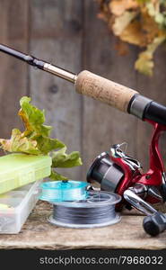 background with fishing tackles on old wooden board with leaf